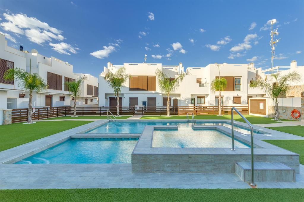 a swimming pool in front of a building at Bahia Homes Residencial in La Horadada