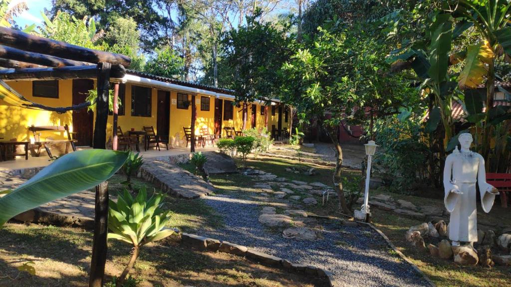 una casa con un maniquí parado frente a ella en Pousada do Sol, en Alto Paraíso de Goiás
