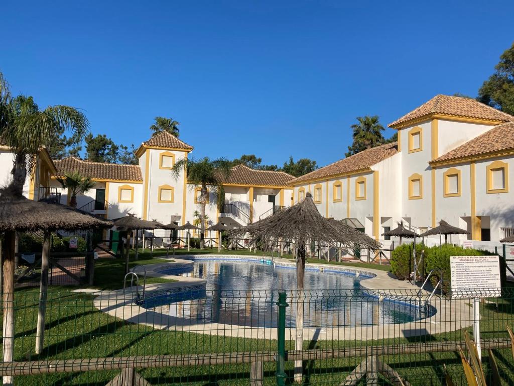a resort with a swimming pool with umbrellas at Playa Golf IV in Islantilla