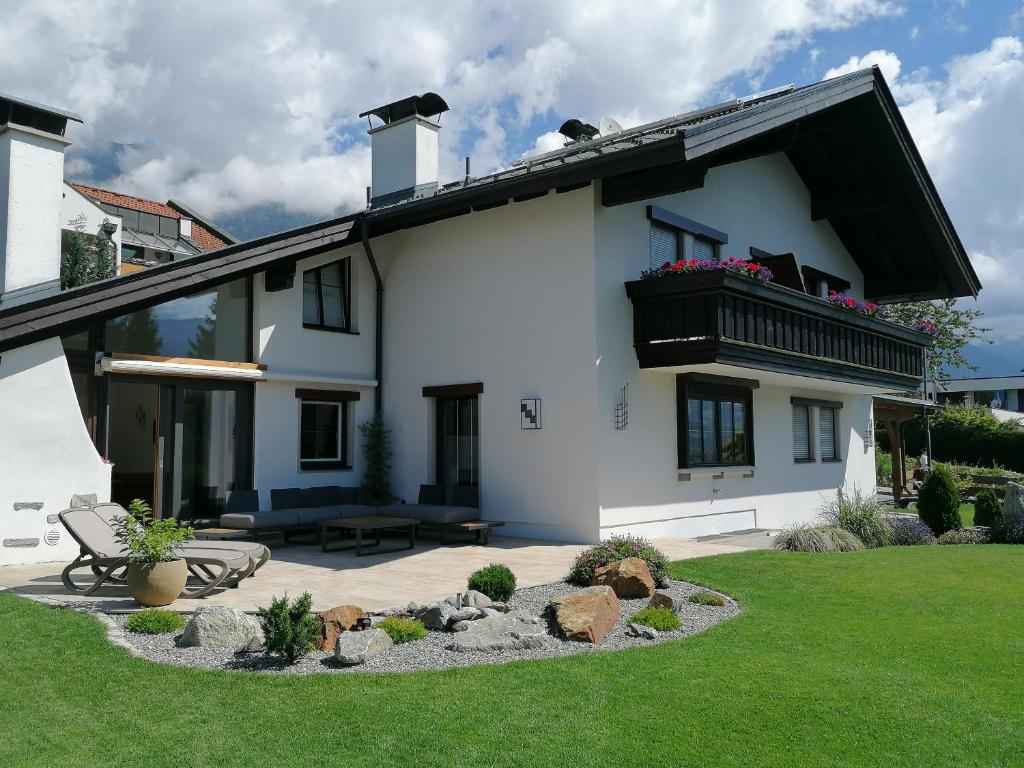ein weißes Haus mit einer Bank im Hof in der Unterkunft Landhaus Plainer in Innsbruck