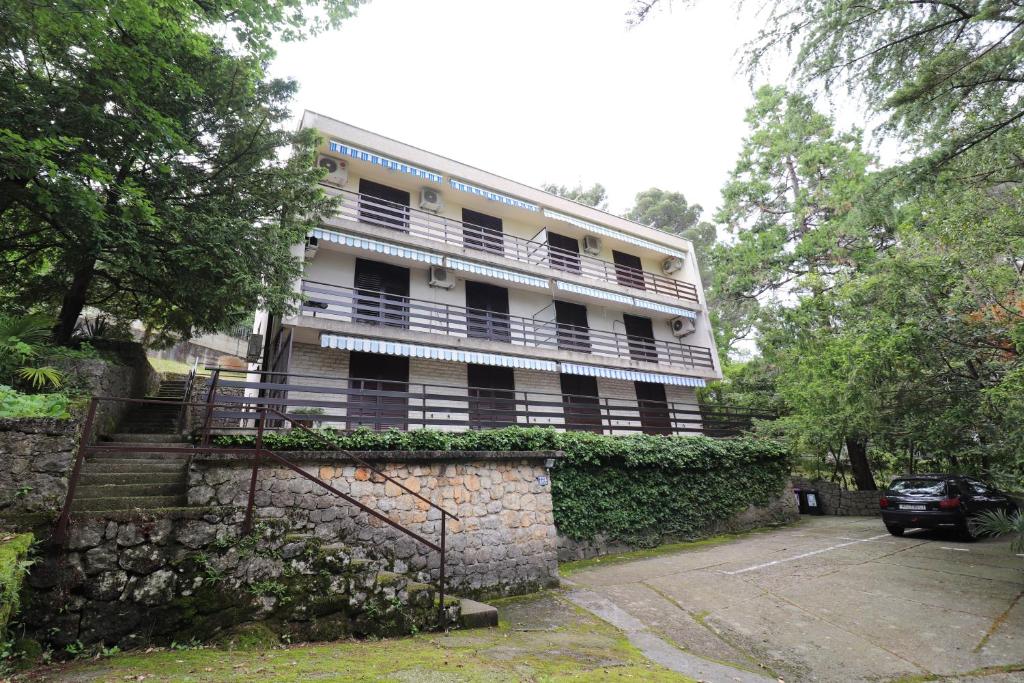 ein Gebäude mit Balkon über einer Steinmauer in der Unterkunft Apartment Gea in Opatija