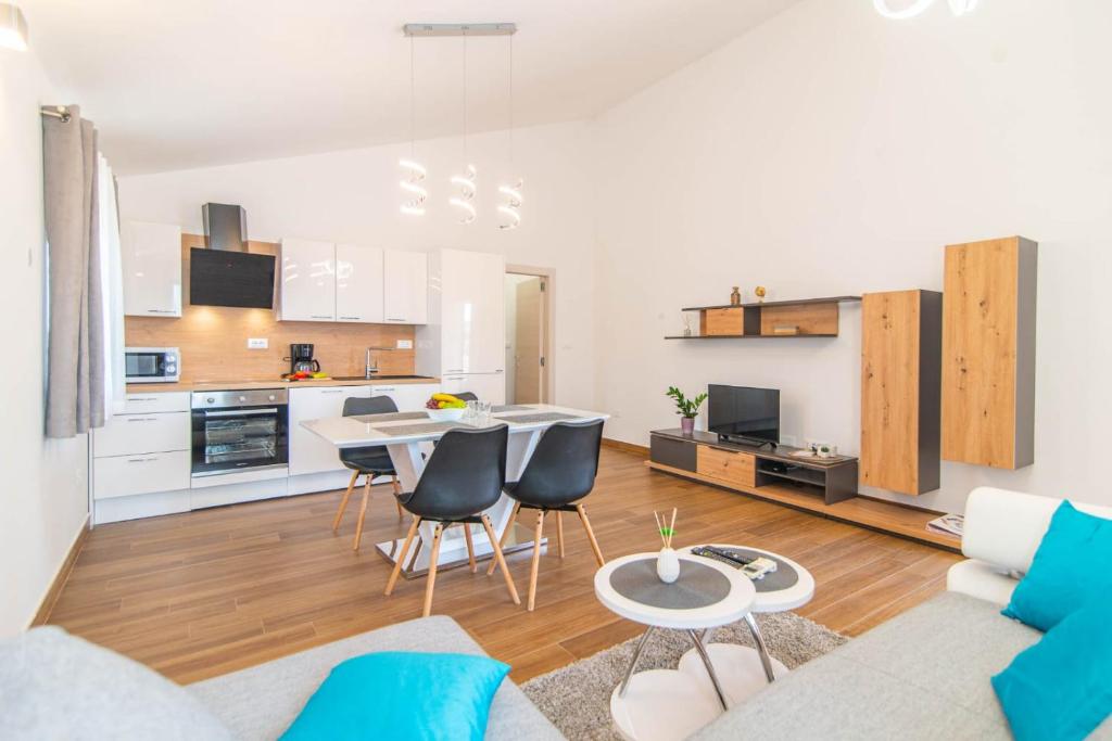 a living room with a table and chairs and a kitchen at Apartment Vabriga in Vabriga