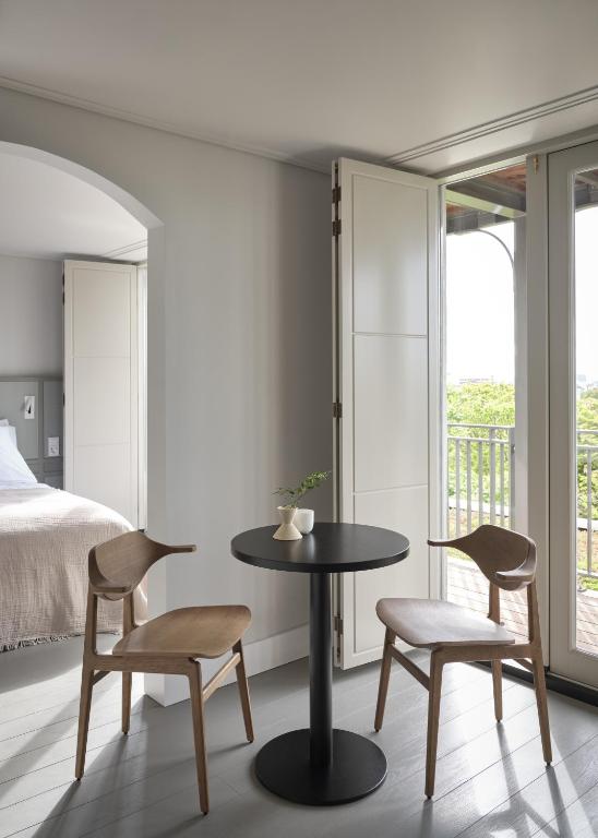una camera da letto con un tavolo, due sedie e un letto di Boutique Hotel Benedict Noordwijk a Noordwijk aan Zee