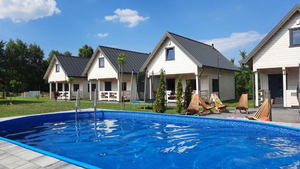 a house with a swimming pool in the yard at Rozmaryn in Bierna