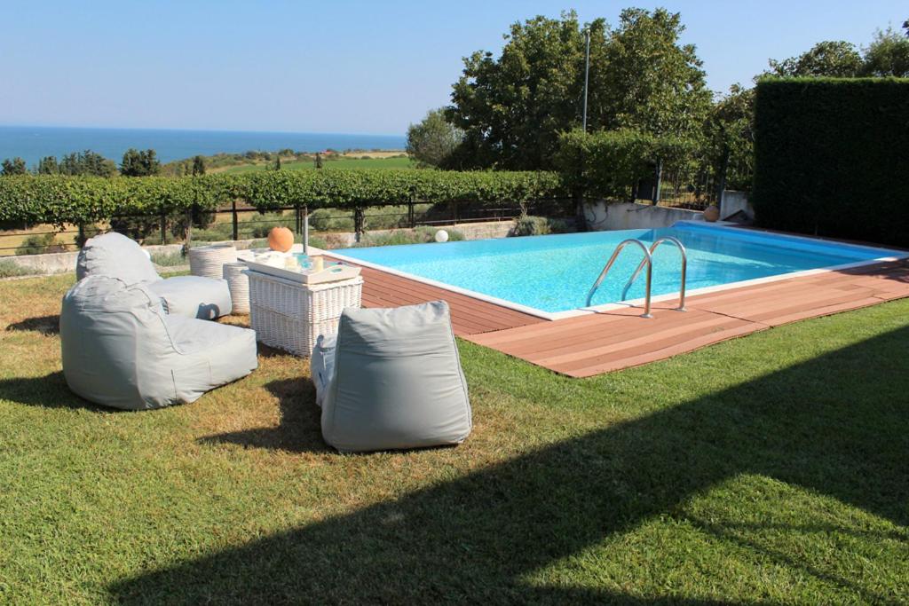 - une piscine avec 2 chaises gonflables à côté dans l'établissement Elikon Luxury Villa, à Modon