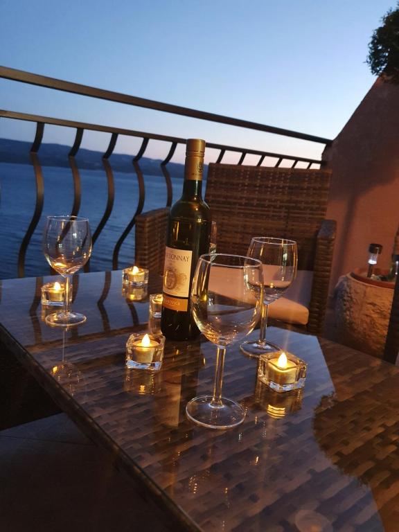 a table with wine glasses and a bottle of wine at Apartment ZaDoDa in Omiš