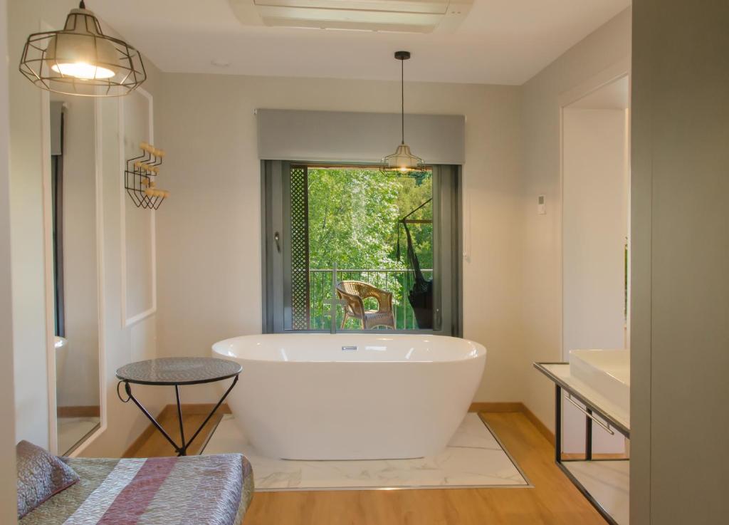 uma grande banheira branca na casa de banho com uma janela em Quinta do Caminho, AL em Valença