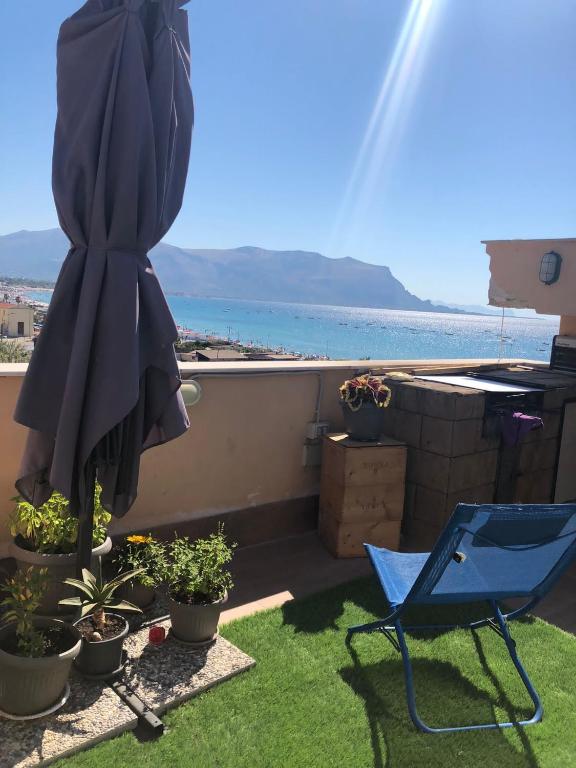 patio z parasolem i krzesłem oraz roślinami w obiekcie Sealoft w mieście Isola delle Femmine