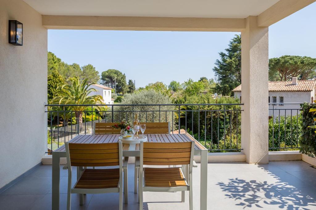 un portico con tavolo e sedie sul balcone di Luxurious and spacious apartment in the heart of the Côte d'Azur a Roquefort-les-Pins