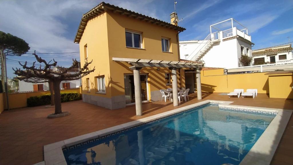 a villa with a swimming pool in front of a house at SANT BRIU in L'Escala