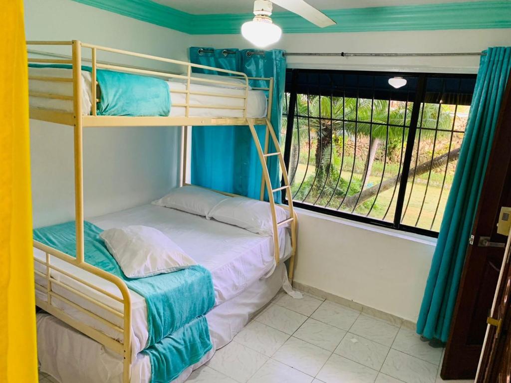 a bedroom with two bunk beds and a window at La Gaviota B1 in Juan Dolio