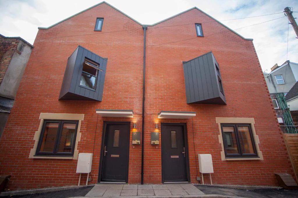 un edificio de ladrillo rojo con dos ventanas. en higgihaus #3a & 3b 8 Bed Sleeps up to 22 Big Groups Hip Location en Bristol