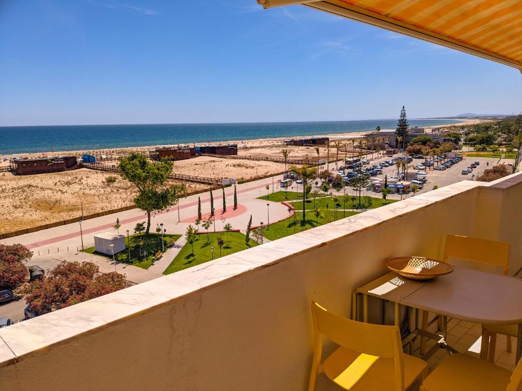 a balcony with a table and chairs and a view of the beach at Seasun Vacation Rentals - BEACH in Monte Gordo
