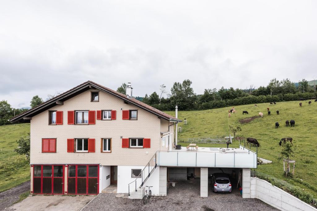 a house with red doors and a grassy hill at B&B Hof Grosschreie in Hasle