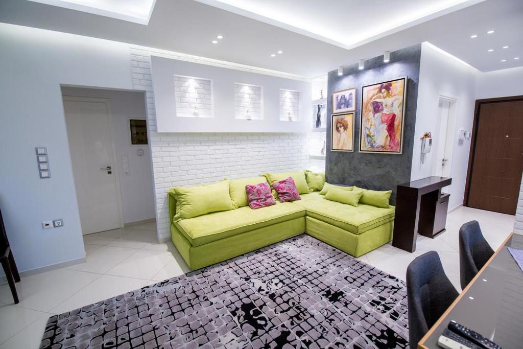 Helen Luxury Loft Design MEISONETTE-APARTMENT في أثينا: غرفة معيشة مع أريكة خضراء في غرفة