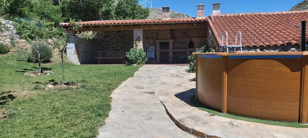 a house with a yard next to a building at CORRAL DEL PRAJONCILLO in Valdecasa