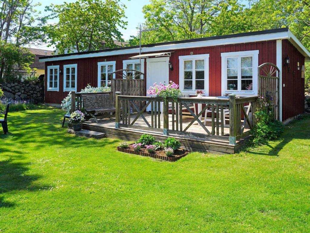 een rood huis met een terras met een tafel bij 5 person holiday home in S LVESBORG in Sölvesborg