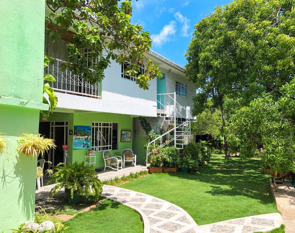 un edificio verde y blanco con patio en Posada Nativa Bernard Place en San Andrés