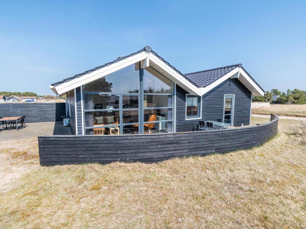 ein Haus mit großen Fenstern auf einem Feld in der Unterkunft Holiday home Fanø CLXXXVI in Fanø