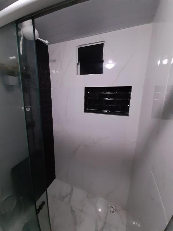 ein Badezimmer mit Glasdusche und Fenster in der Unterkunft PORTO GALINHAS TODO MOBILIADO 5 minutos a pé da praia in Porto De Galinhas