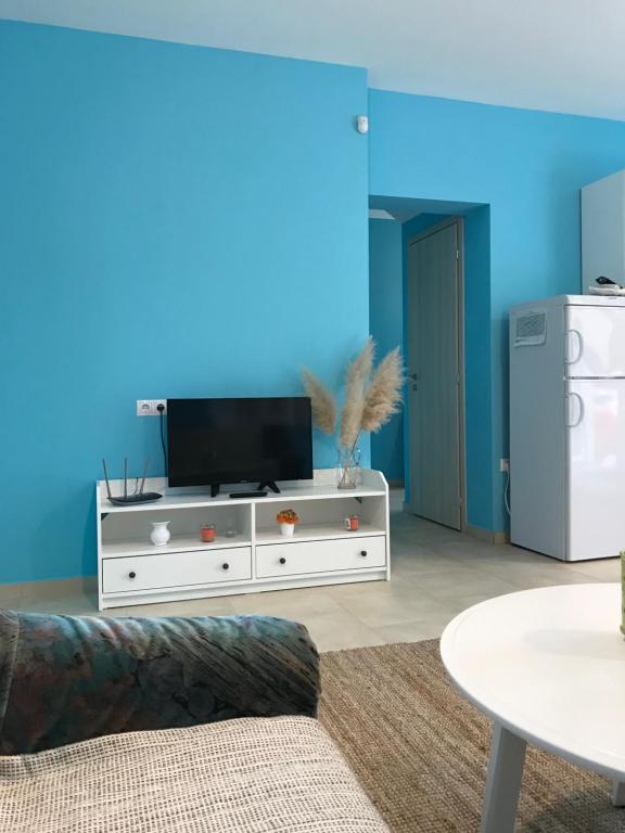 salon z telewizorem i niebieską ścianą w obiekcie Szárszószép Villa w mieście Balatonszárszó