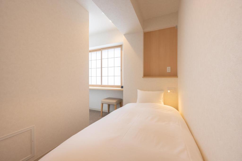 Postel nebo postele na pokoji v ubytování Fuji Hotel Kyoto Gojo