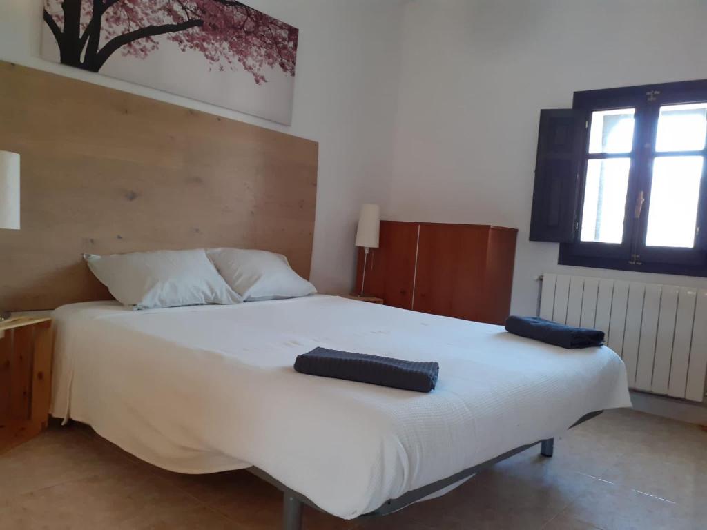 1 dormitorio con 1 cama blanca grande y 2 almohadas en El Molí, en Ulldemolins