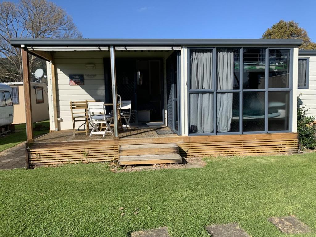 a screened in porch of a house with a table at Te Puru B8 - 2 bedroom chalet in Te Puru