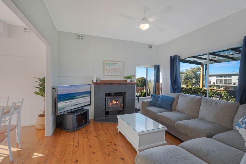 a living room with a couch and a fireplace at Bungo Beach house - Pet Friendly home in Eden