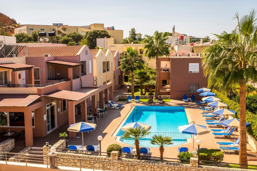 an aerial view of a resort pool with umbrellas at Theos Holidays Apartments in Kato Daratso