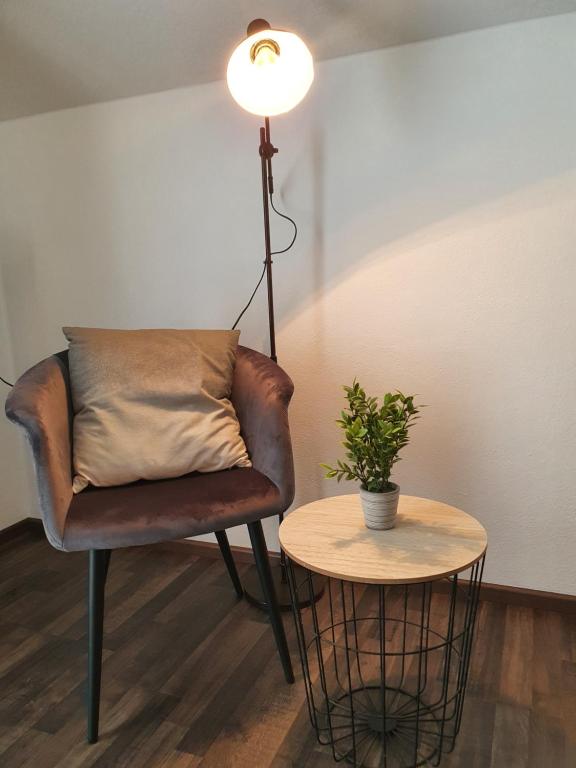 a chair and a table with a pillow and a lamp at Kurhotel Anders in Bad Füssing