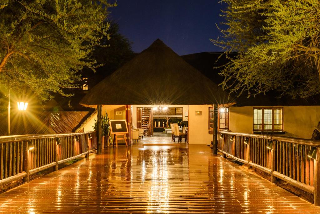un porche cubierto de lluvia de una casa por la noche en Mongena Private Game Lodge en Rust de Winter