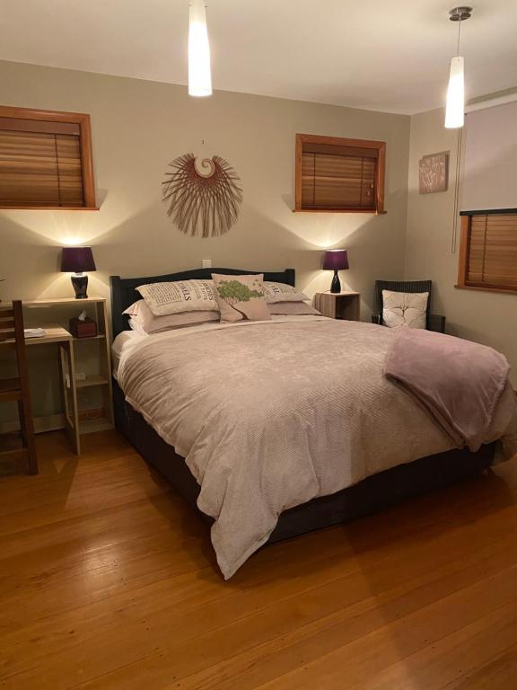 a bedroom with a large bed and a desk at Adventure B&B in Takaka
