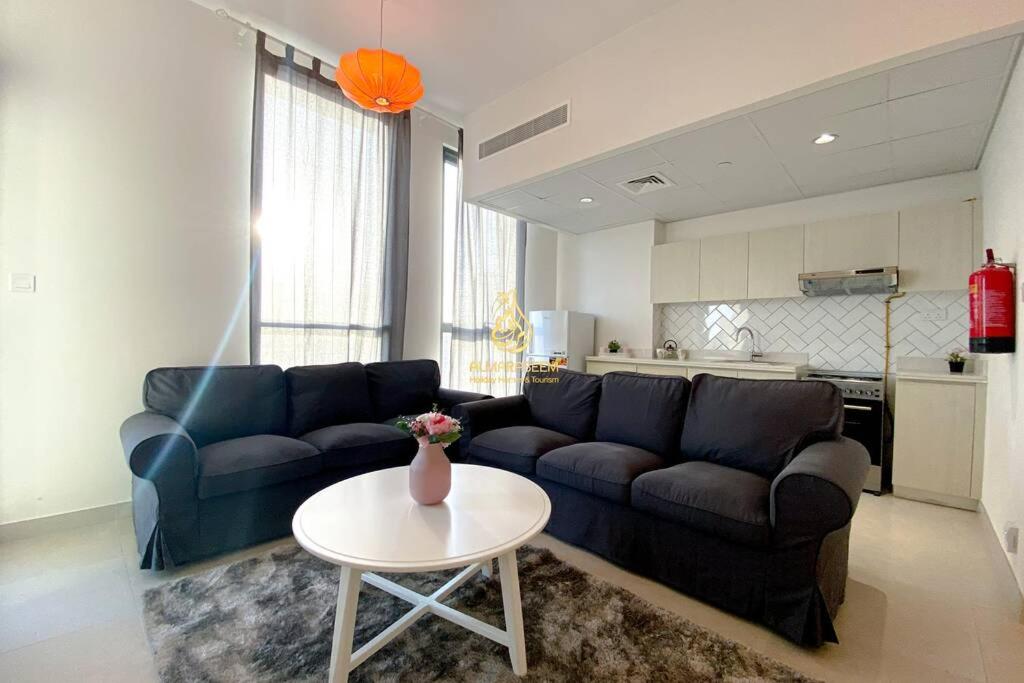 a living room with a couch and a table at Dania 3 Midtown - AL Maraseem in Dubai