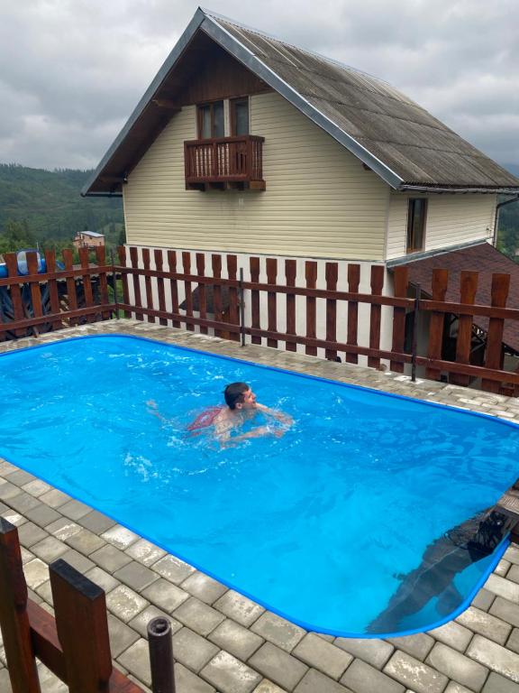 un hombre en una piscina en una casa en Біля лісу (Апартаменти для сім'ї), en Slavske