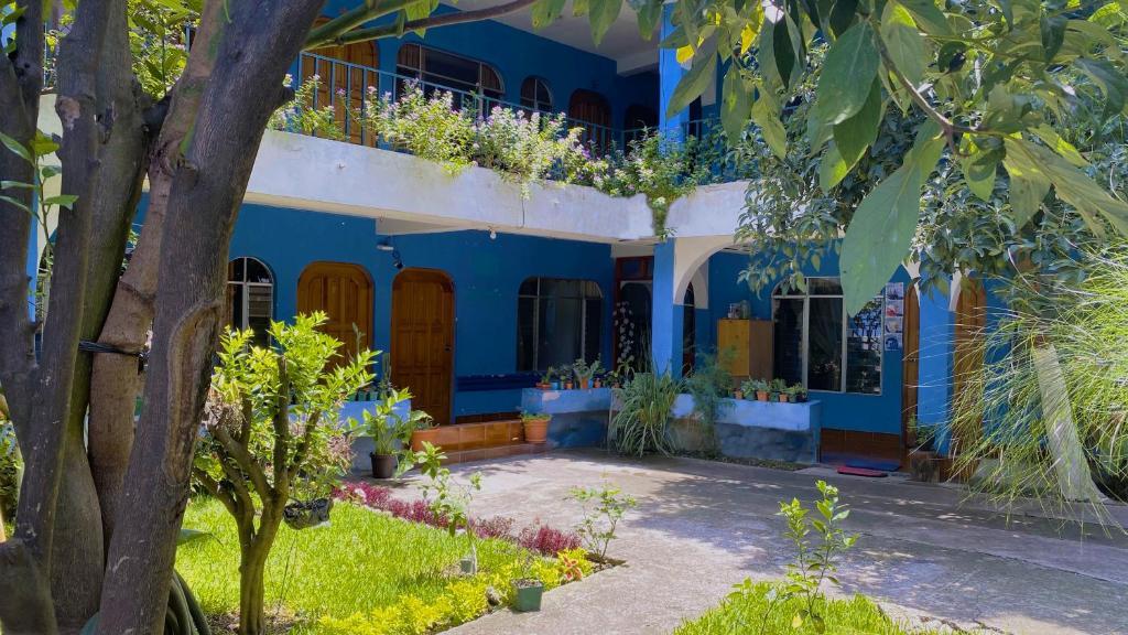 un edificio azul con un balcón con plantas. en Hotel Posada Don Carlos en Panajachel