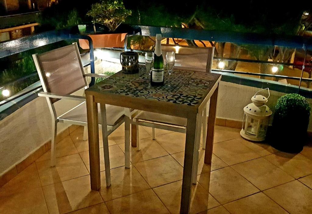 uma mesa com duas cadeiras e uma garrafa de vinho em MariBlau em Platja d'Aro