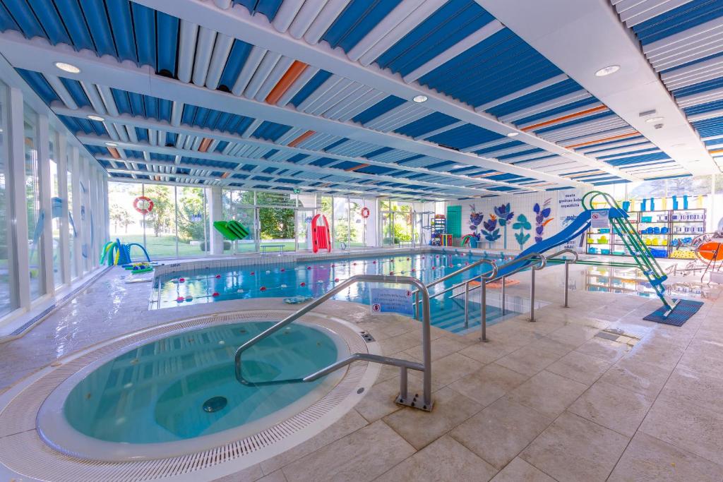 a large swimming pool with a hot tub in a building at Maraini Elegante - Happy Rentals in Lugano