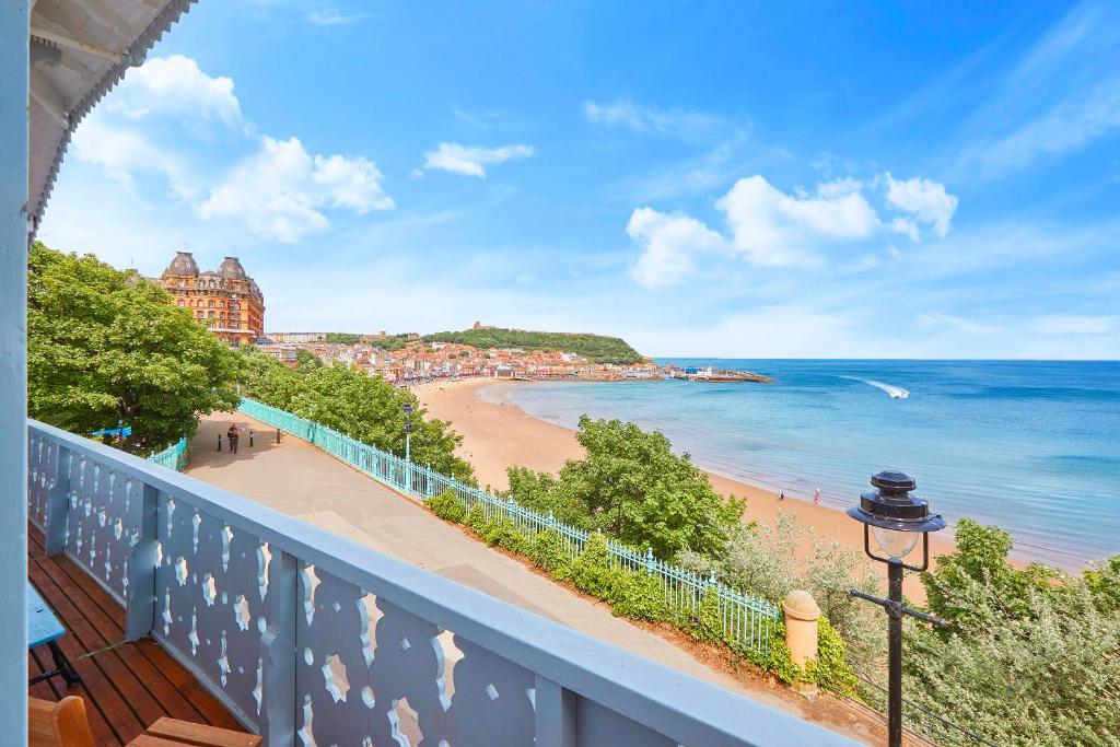 een balkon met uitzicht op het strand en de oceaan bij The Spa Chalet Scarborough Hot tub, pool, gym, beach location in Scarborough