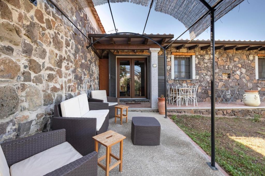 un patio esterno con divani e un muro in pietra di Casa Sole a Dorgali