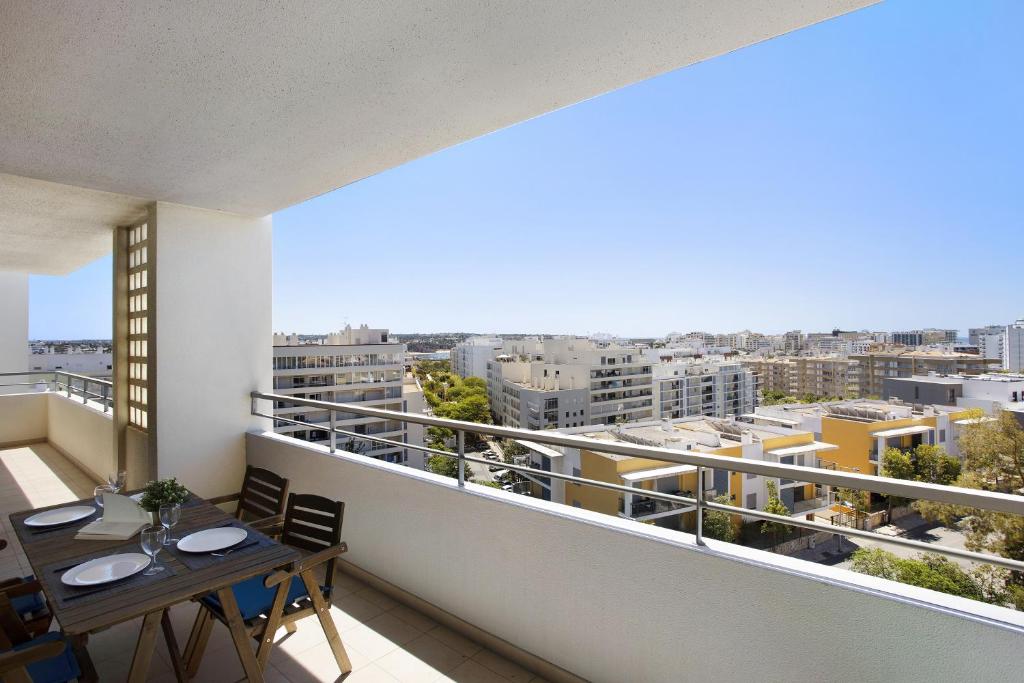 uma varanda com uma mesa e vista para a cidade em Villa Rosa Apartment em Portimão