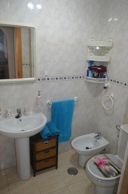 łazienka z umywalką, toaletą i lustrem w obiekcie Apartamento Belsol w mieście Torrevieja
