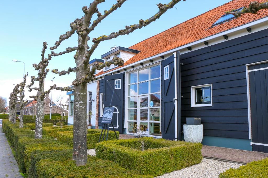 ein blaues Haus mit Bäumen davor in der Unterkunft Oostmolenhoeve B&B in Goes