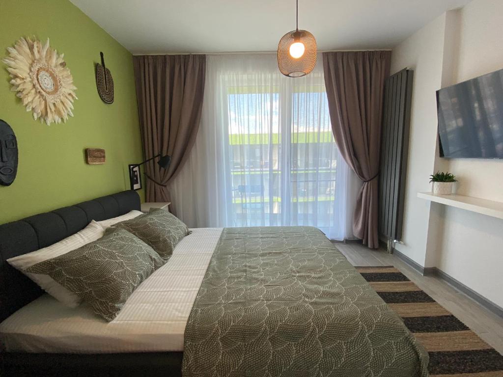 - une chambre avec un lit et une grande fenêtre dans l'établissement Rakish Moon Apartment, à Mamaia Nord – Năvodari