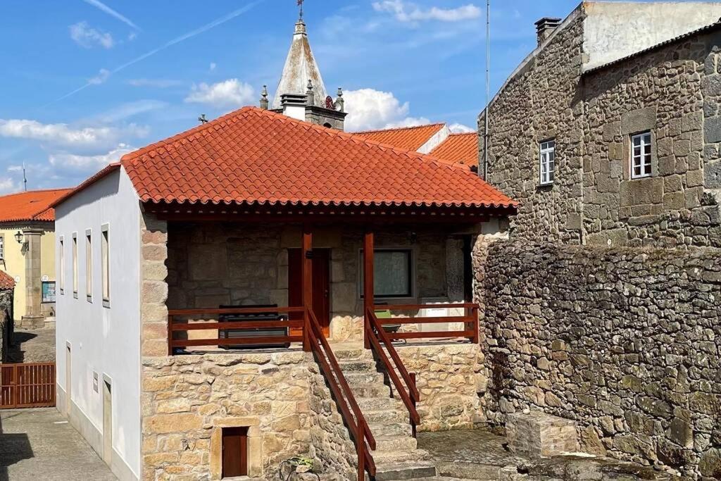 a building with a red roof and a tower at Casa de Sampaio - Castelo Mendo in Castelo Mendo