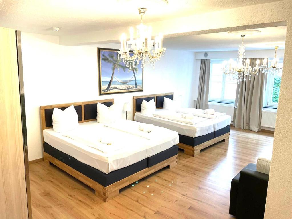 - une chambre avec 2 lits et un lustre dans l'établissement Hotel Garni Anker, à Lindau