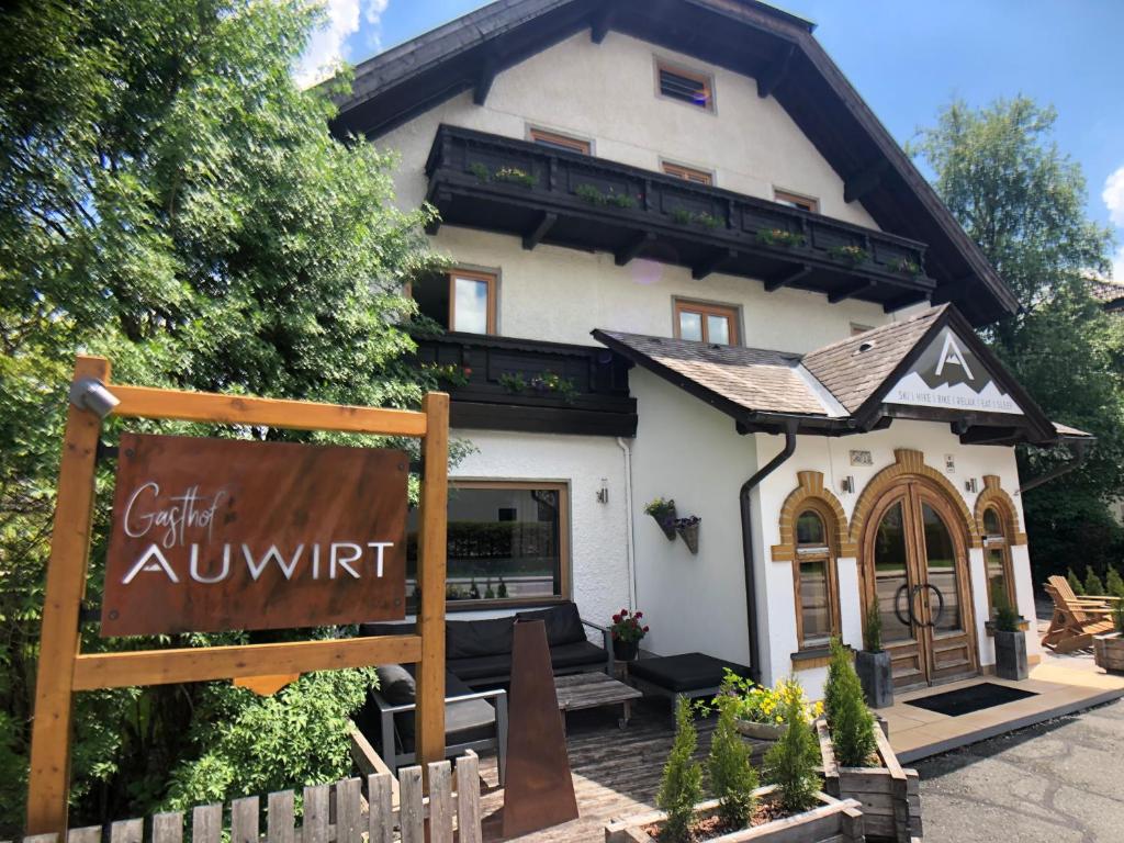 a large white house with a sign in front of it at Gasthof Auwirt in Sankt Michael im Lungau