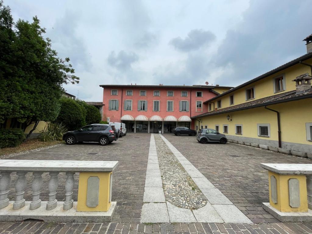 um grande edifício vermelho com carros estacionados num parque de estacionamento em Bes Hotel Bergamo Cologno al Serio em Cologno al Serio