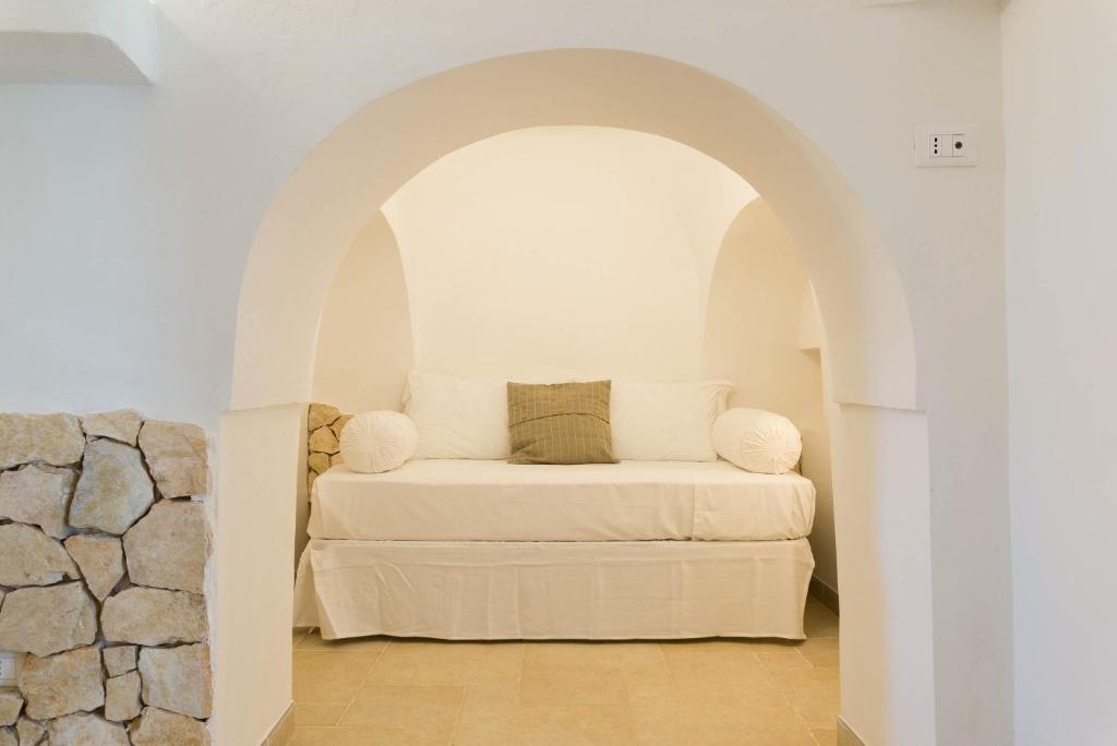 - une chambre avec un canapé blanc en voûte dans l'établissement Charming Villas - Villa d'Itria with trullo, à Ostuni