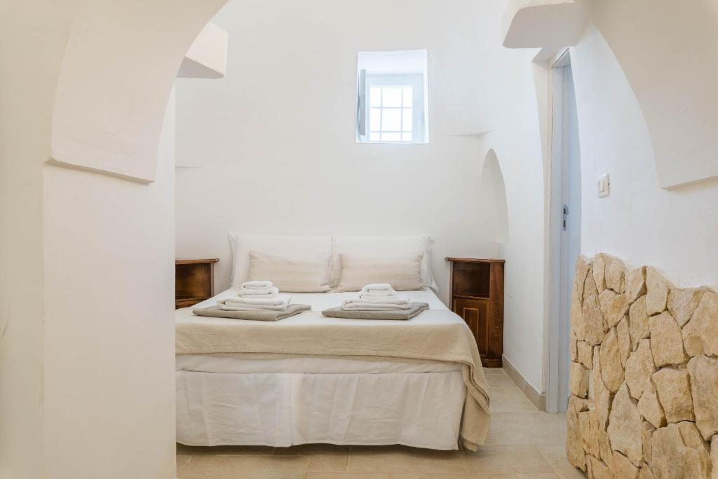 une chambre blanche avec un lit dans une chambre blanche dans l'établissement Charming Villas - Villa d'Itria with trullo, à Ostuni 79 autres photos